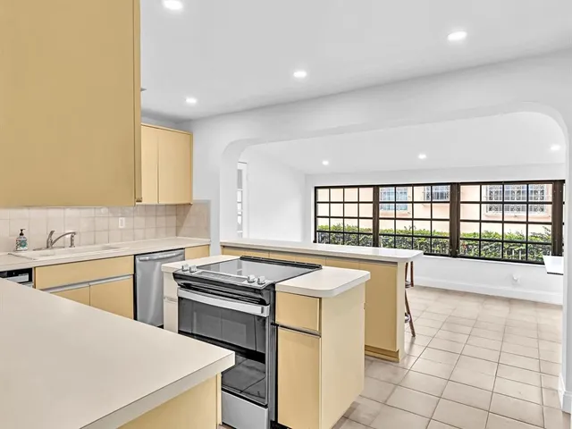 a kitchen with a sink a stove a refrigerator and white cabinets
