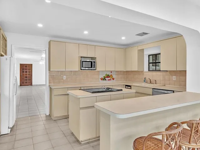 a view of an empty room and chandelier fan