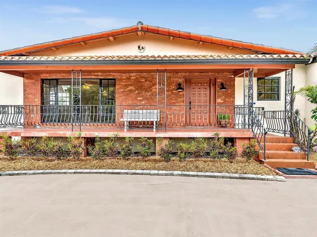 a view of a house with a porch and a yard