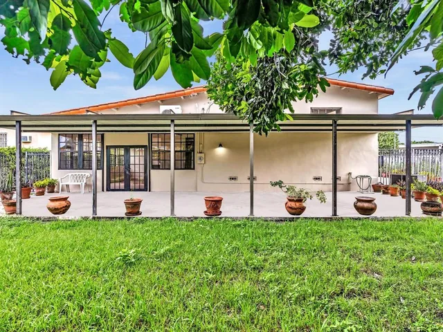 a view of a patio with a table chairs and a backyard