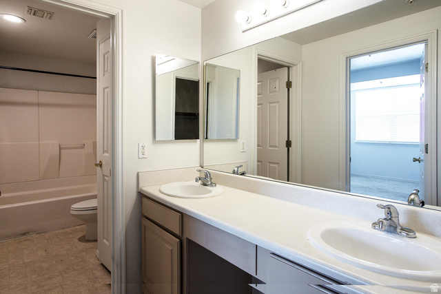 900 Bitner Road, Unit H35 Park City, UT 84098 - Photo 7 of 14 Dual-sink vanity featuring white porcelain basins, wood-finish cabinetry, and a continuous countertop with chrome faucet fixtures
