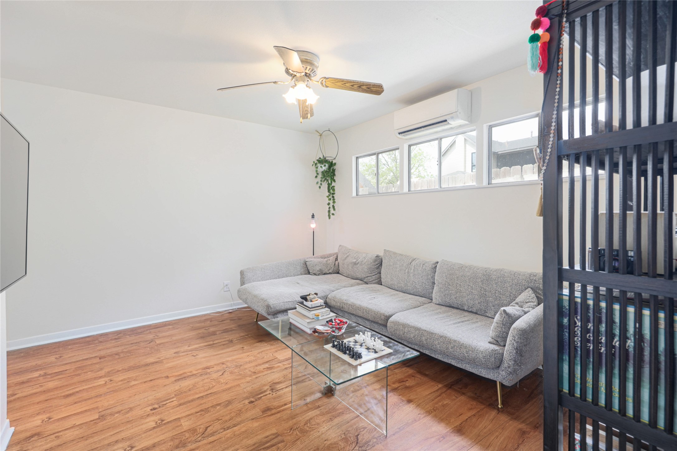 4607 Evans Avenue, Unit B Austin, TX 78751 - Photo 9 of 34 Living area featuring wood-finish flooring, a ceiling fan with light fixture, and multiple windows for natural light