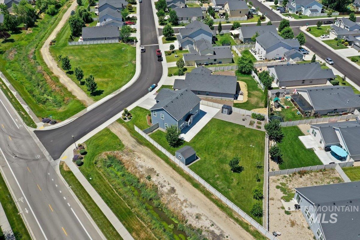 12310 West Hidden Point Drive Star, ID 83669 - Photo 35 of 48 Residential property featuring a spacious grass lawn, paved driveway, and perimeter fencing