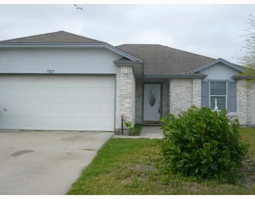 a brick house with a small yard and a large window