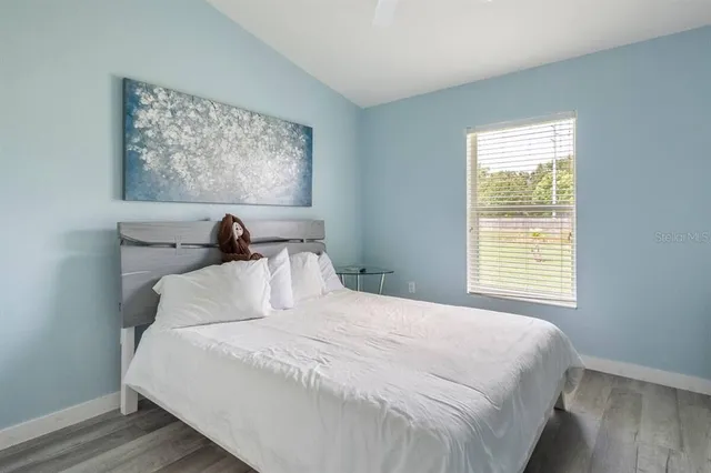 a bedroom with a bed and a painting on the wall