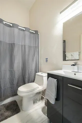 a bathroom with a sink vanity mirror and toilet