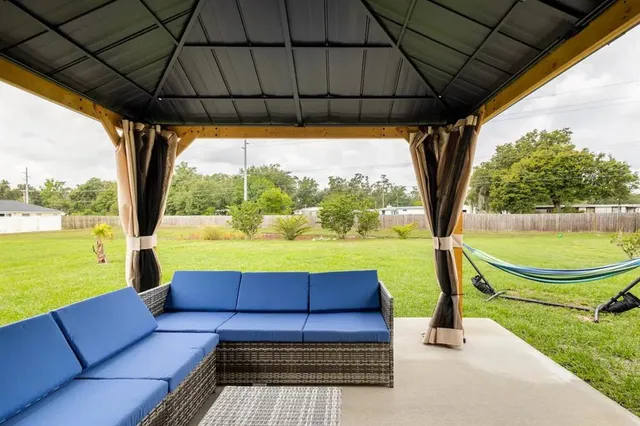 a view of yard with a table and chair under an umbrella
