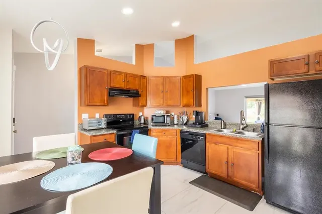 a kitchen with stainless steel appliances granite countertop a stove a sink dishwasher and a refrigerator