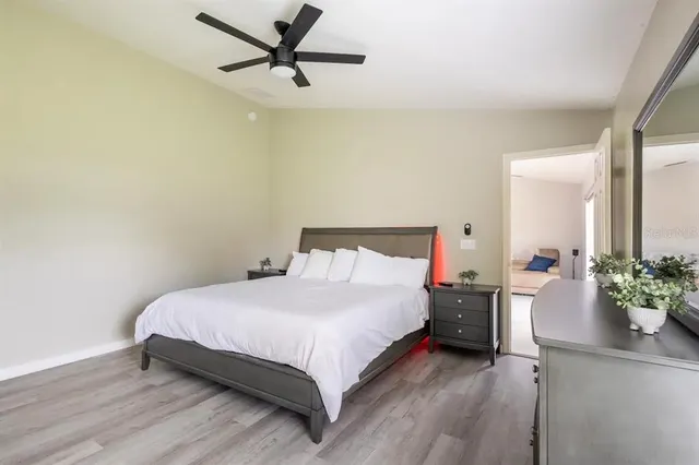 a bedroom with a bed chandelier and a dresser