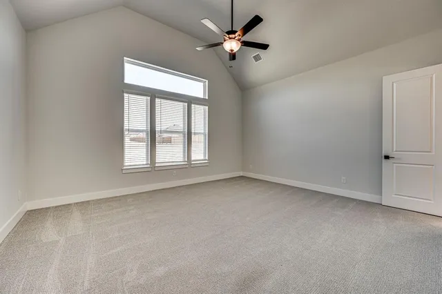 an empty room with windows and fan