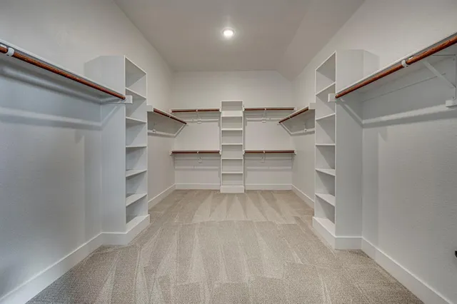 a view of walk in closet with empty racks