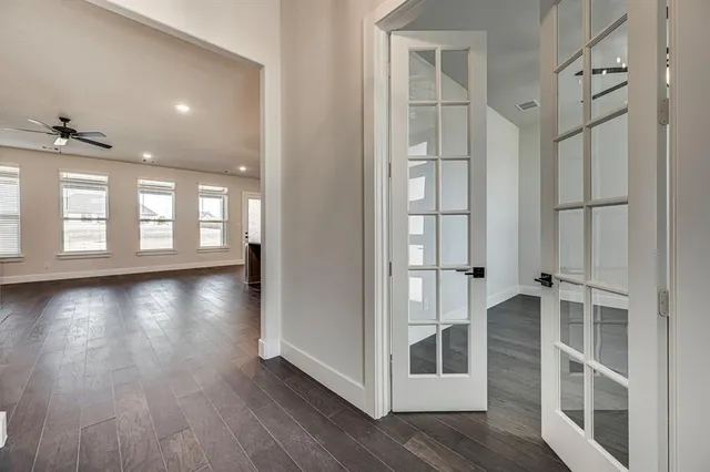 a view of a hallway with wooden floor and windows