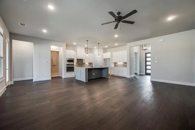 a view of a livingroom with a kitchen and wooden floor