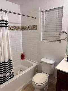 a white toilet sitting next to a bath tub and a shower