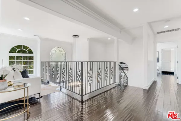a view of a hallway with wooden floor and windows