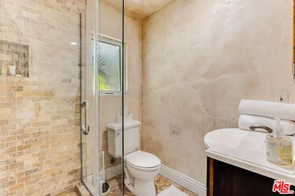 a bathroom with a sink a toilet and shower