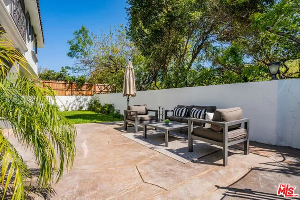 a view of patio with table and chairs and potted plants