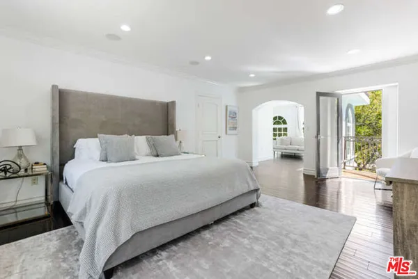 a spacious bedroom with a bed and a large window