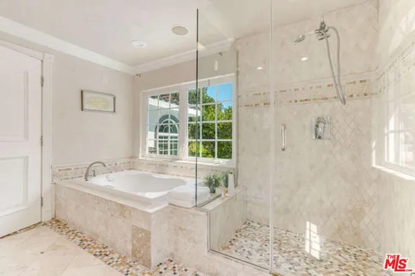 a spacious bathroom with a tub sink and shower