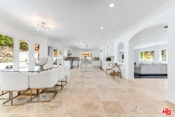 a living room with furniture and a dining table with kitchen view