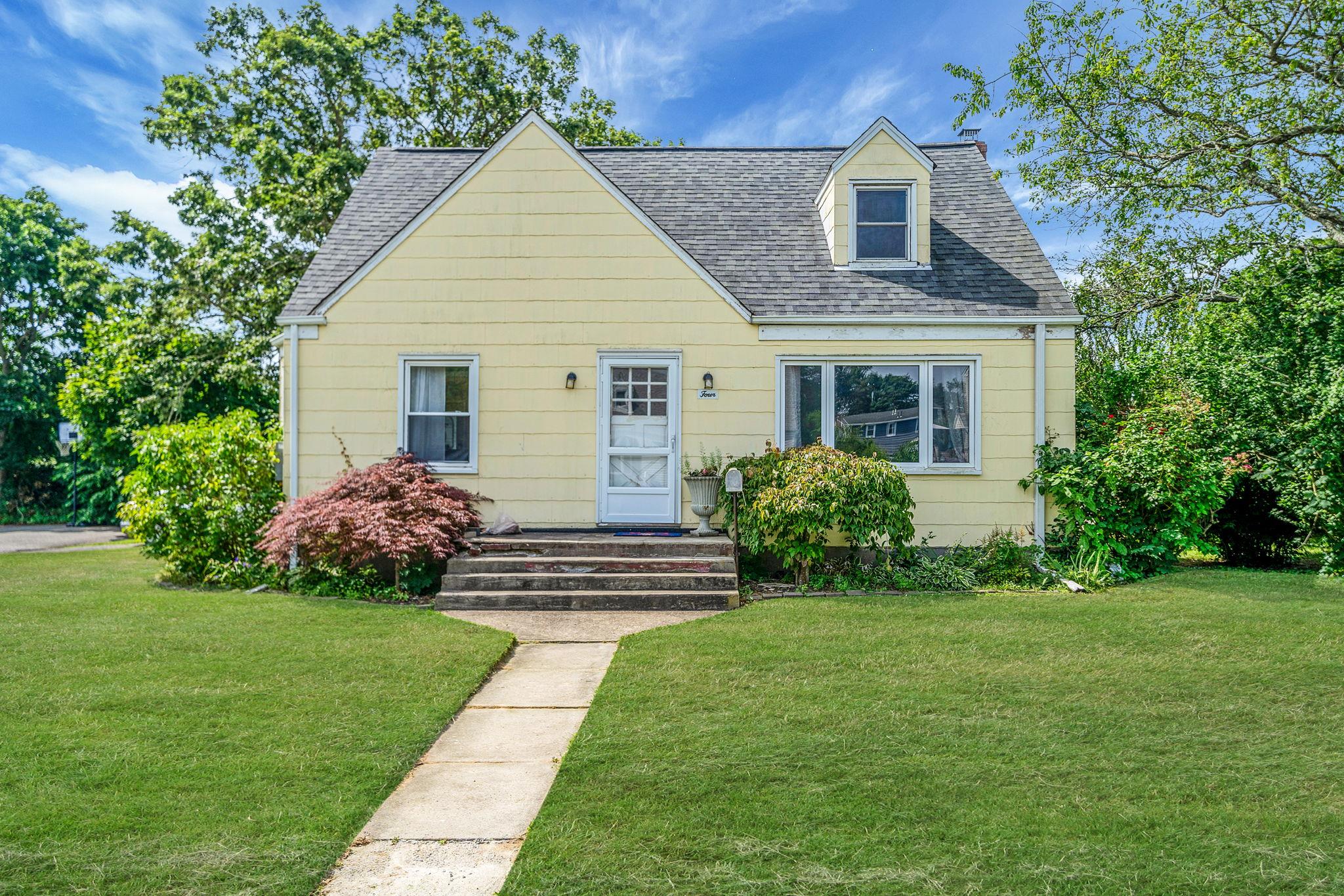 View of front of property with a shingled roof and a front lawn