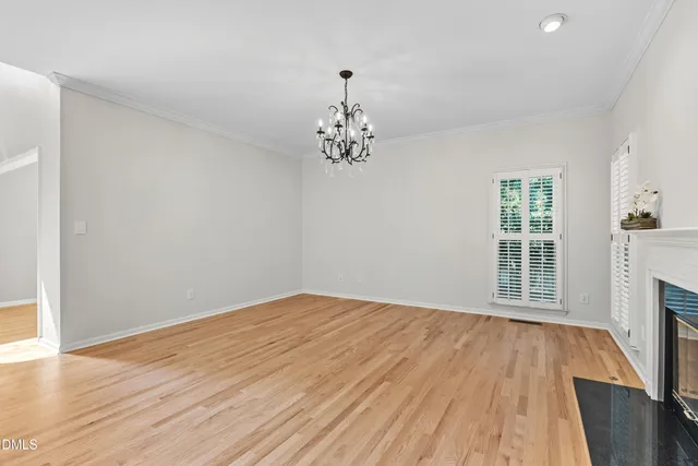 a view of a livingroom with a fireplace a chandelier and windows