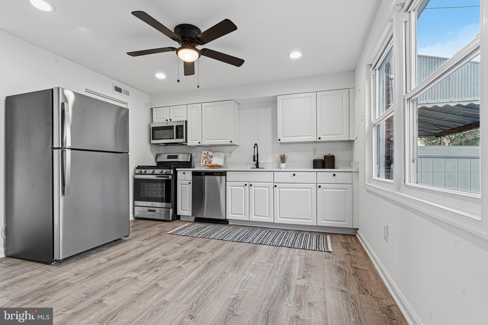 8110 North Boundary Road Dundalk, MD 21222 - Photo 8 of 24 a kitchen with white cabinets and stainless steel appliances