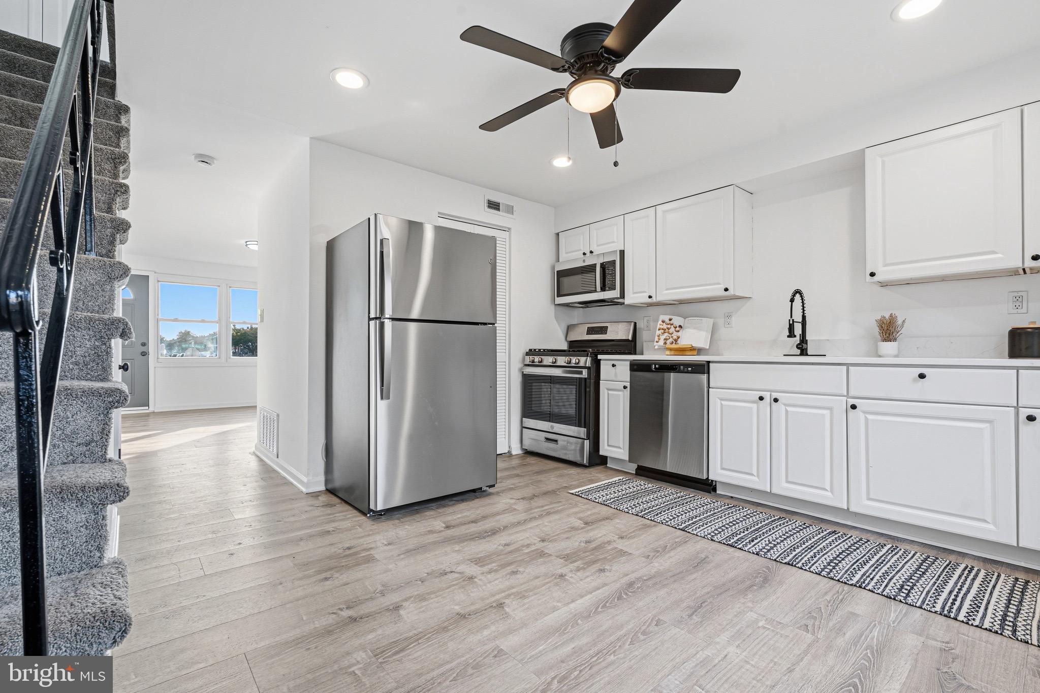 8110 North Boundary Road Dundalk, MD 21222 - Photo 9 of 24 a kitchen with kitchen island white cabinets and stainless steel appliances