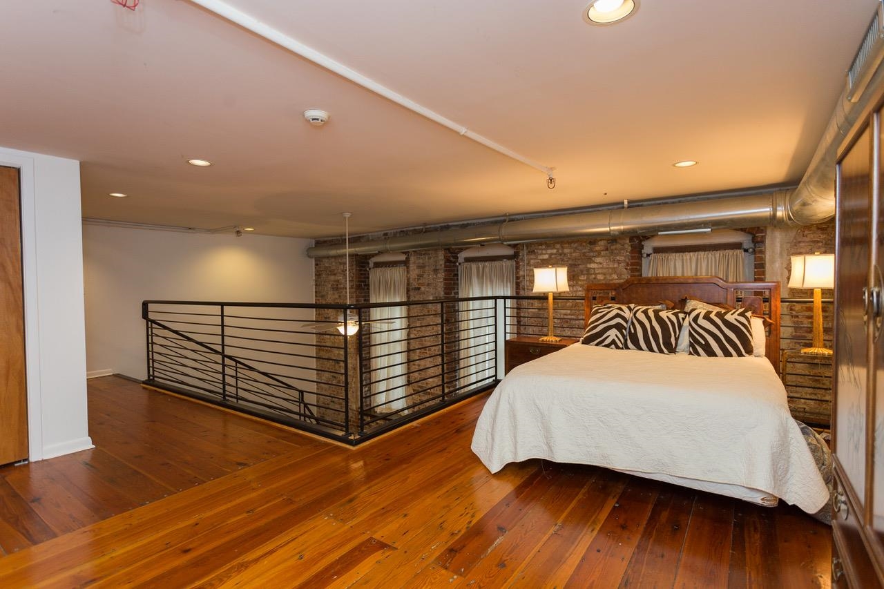 50 Gayoso Avenue, Unit 306 Memphis, TN 38103 - Photo 20 of 25 a bedroom with a bed and a wooden floor