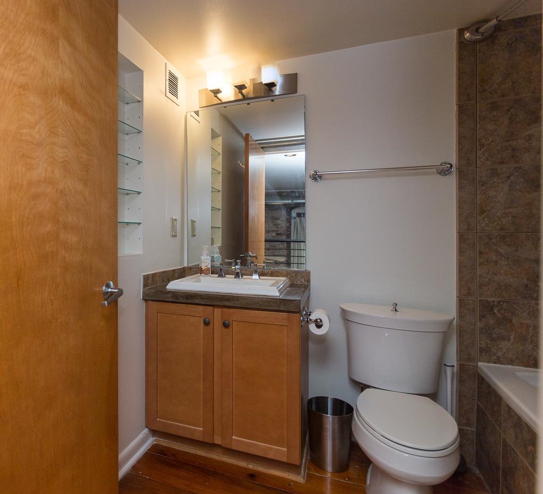 50 Gayoso Avenue, Unit 306 Memphis, TN 38103 - Photo 23 of 25 a bathroom with a granite countertop toilet sink and mirror