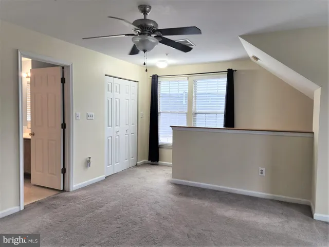 a view of an empty room with a ceiling fan