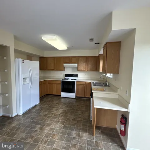 a kitchen with granite countertop a sink cabinets stainless steel appliances and a counter top space