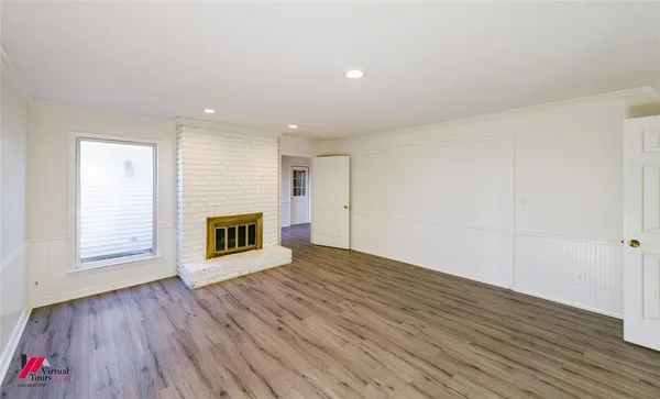 an empty room with wooden floor and fireplace