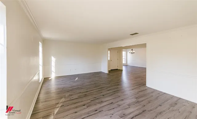 a view of an empty room with wooden floor
