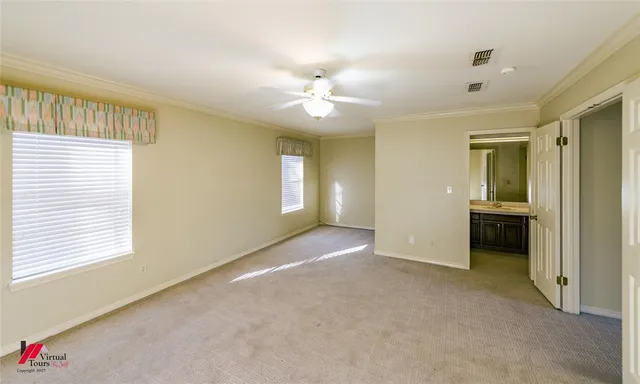 a view of a livingroom with a chandelier fan and windows