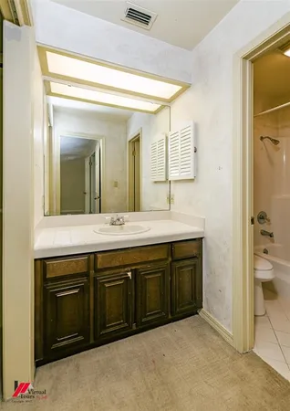 a spacious bathroom with a granite countertop sink and a mirror