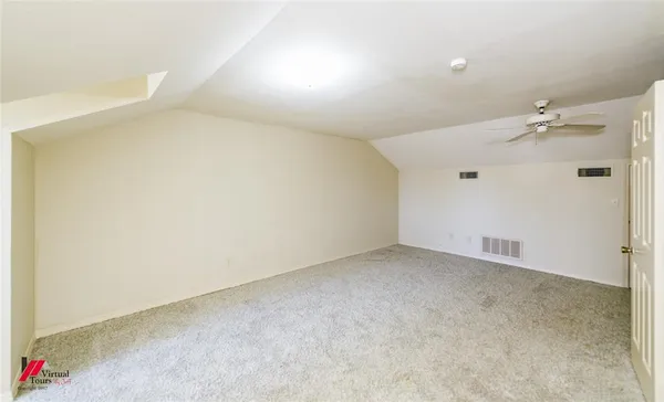 an empty room with a chandelier fan