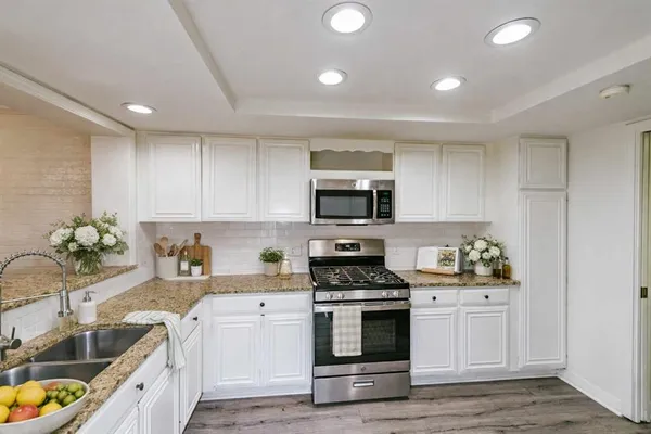 a kitchen with stainless steel appliances a stove a sink a microwave and cabinets
