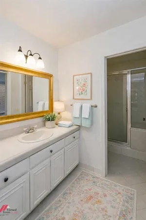a spacious bathroom with a granite countertop sink and a mirror