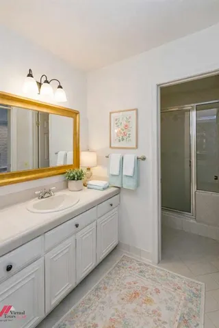 a spacious bathroom with a granite countertop sink and a mirror