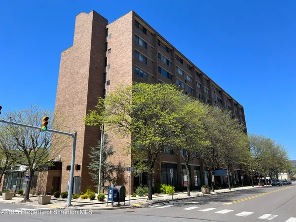 a view of a tall building next to a yard