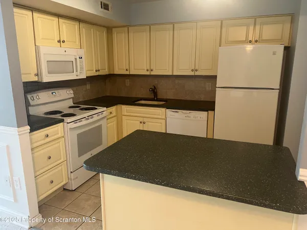 a kitchen with a refrigerator stove and cabinets