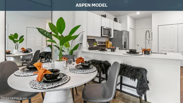 a kitchen with stainless steel appliances a sink a stove a microwave a refrigerator and cabinets