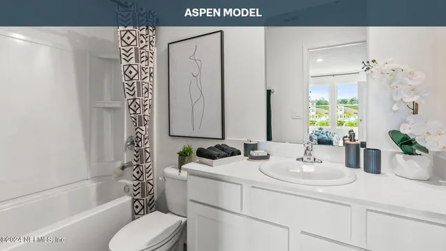 a spacious bedroom with a bed a clock on the wall and a table