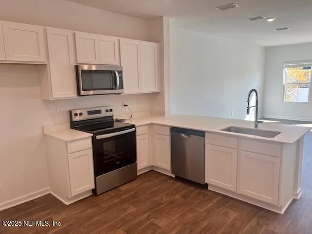 a kitchen with a sink stainless steel appliances and white cabinets