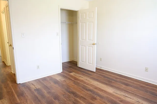 an empty room with wooden floor and a window