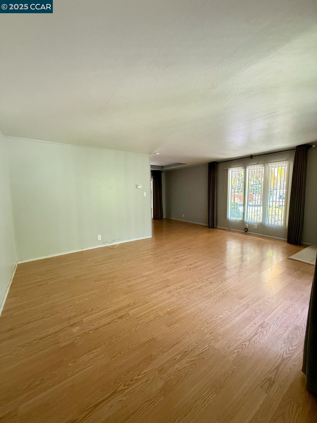 2061 Vanderslice Avenue Walnut Creek, CA 94596 - Photo 6 of 15 an empty room with wooden floor and windows