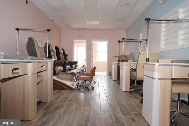 a living room with furniture a refrigerator and wooden floor