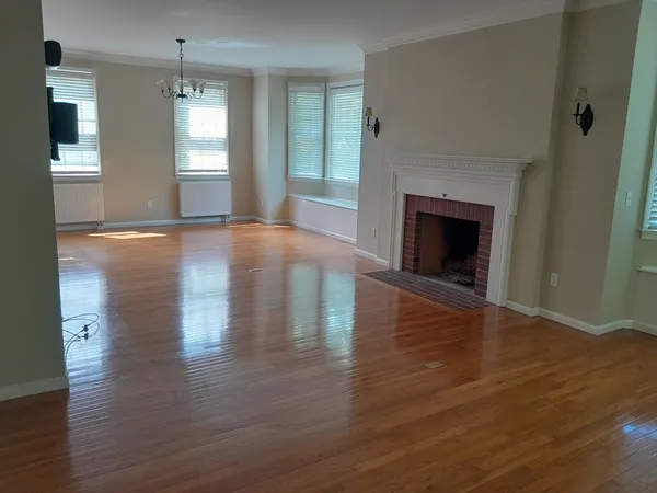 a view of empty room with wooden floor and fireplace