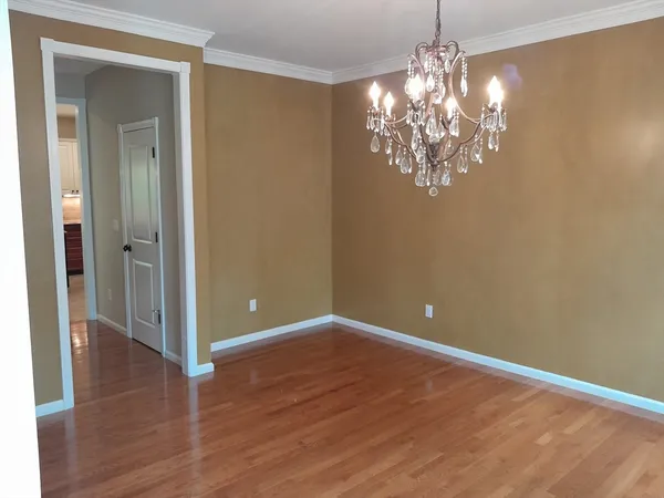 a view of a chandelier in big room and wooden floor